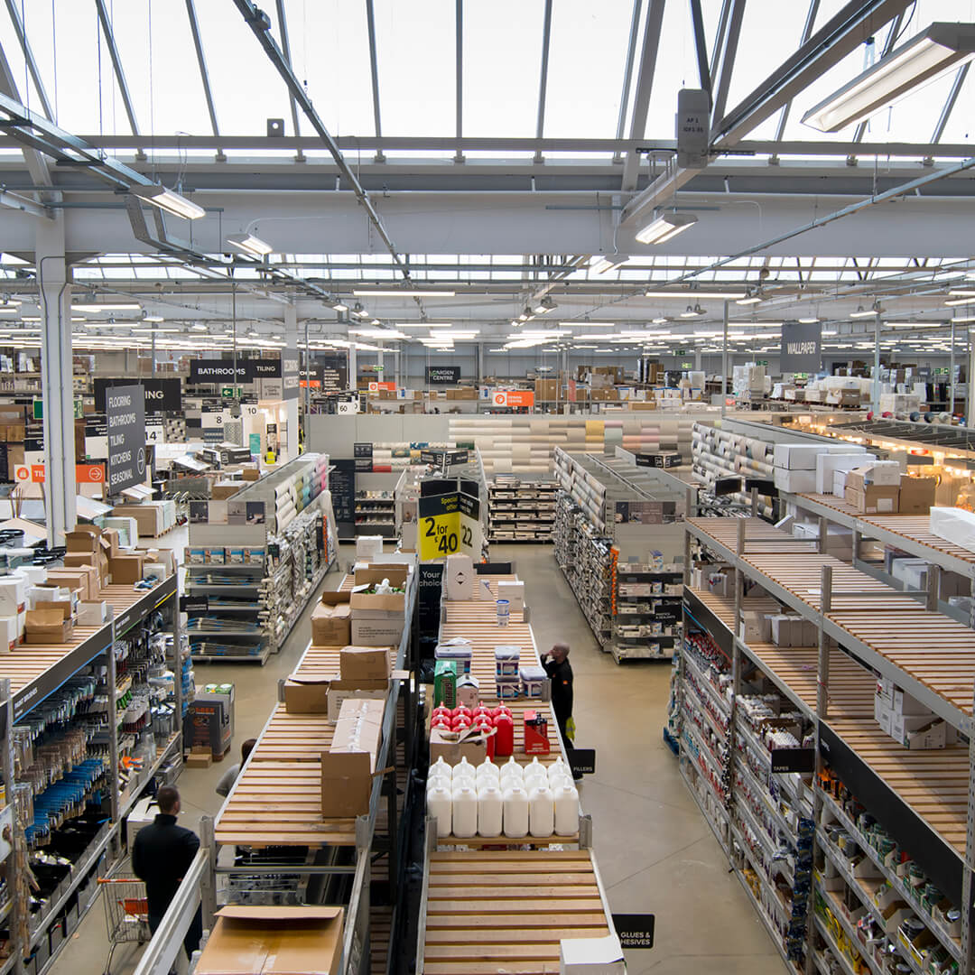 A large store with high ceilings and numerous aisles filled with various building materials and tools.