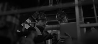 Two water facility workers wearing hardhats.